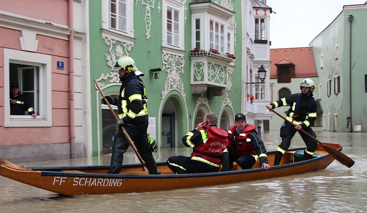 Feuerwehrbedienstete in einem Boot in einem Überschwemmungsgebiet